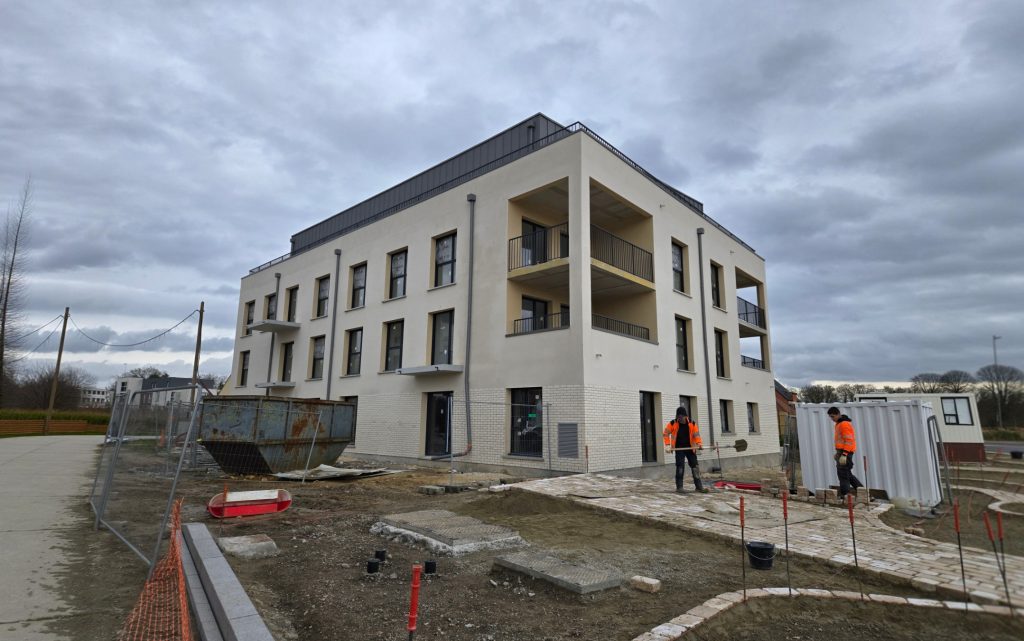 Application d'enduit de façade sur un grand immeuble de logements collectifs avec rez-de-chaussée en parement brique à Compiègne.
