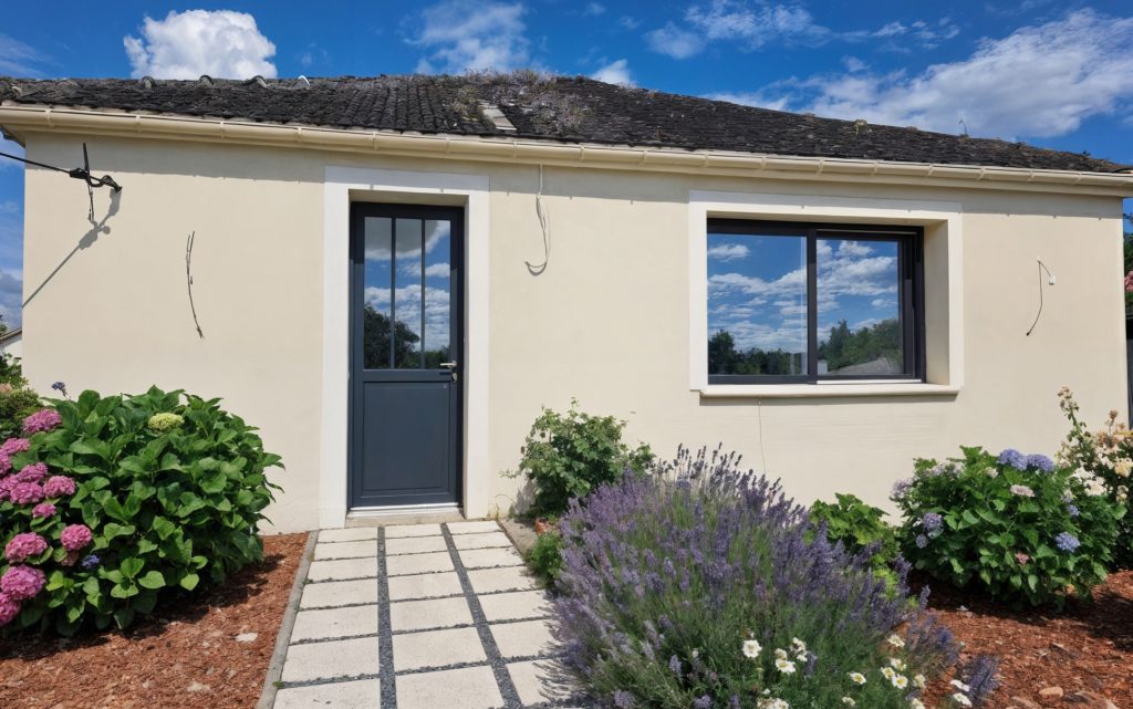 Façade rénovée d'une maison de plain-pied avec enduit clair et création d'encadrements blancs autour des menuiseries dans l'Oise.