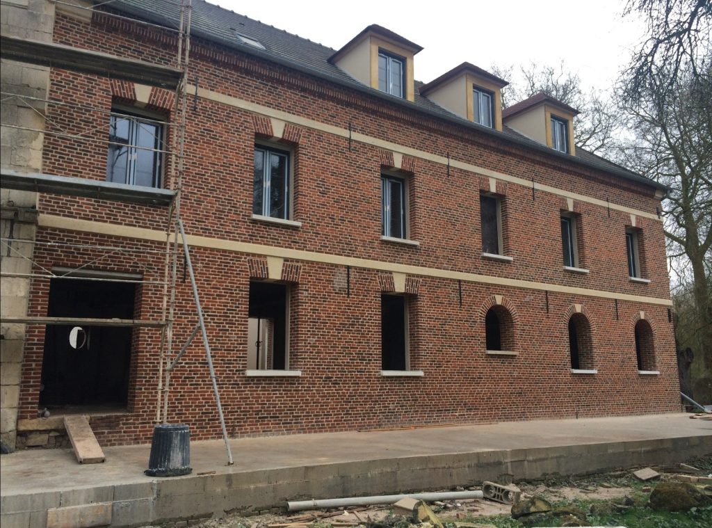 Rénovation d'une grande façade traditionnelle en brique rouge avec rejointoiement et restauration des encadrements clairs dans l'Oise.