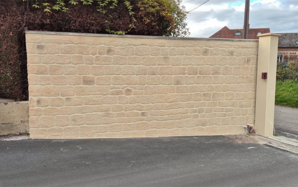 Chantier de ravalement de façade en cours sur une maison avec échafaudage et bâches de protection au sol dans l'Oise.